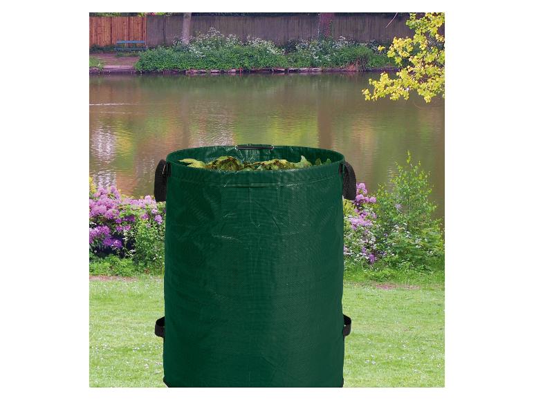 Sac de jardin vert rempli de feuilles, avec un lac et de la verdure en arrière-plan.