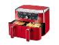 Friteuse à air rouge à double panier avec poulet rôti et frites.