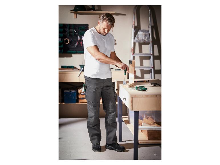 Un homme travaille avec des tournevis dans son atelier.