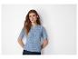 Une femme portant un pull en maille bleu clair à manches courtes.