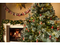 Sapin de Noël enneigé avec décorations et cheminée allumée, guirlande et calendrier de l'Avent.