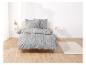 Une parure de lit grise avec un motif floral blanc.