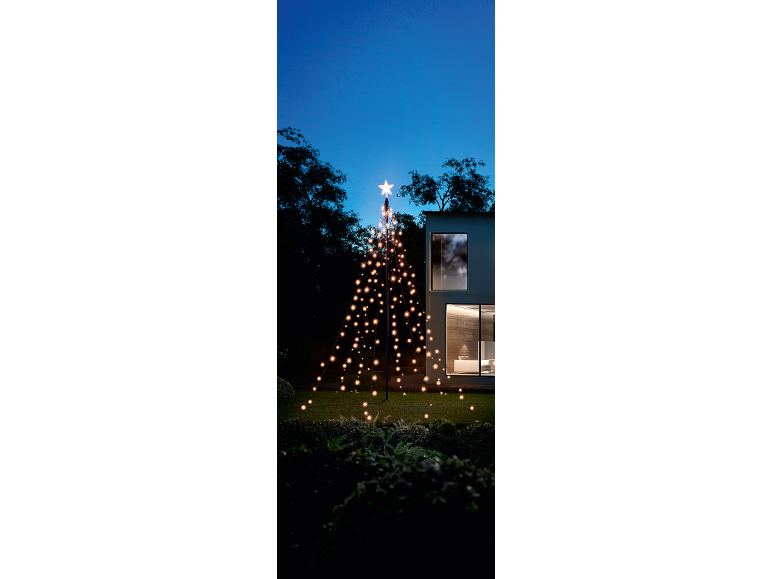 Sapin de Noël extérieur lumineux avec guirlandes en forme d'étoiles sur une pelouse devant une maison.