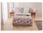 Parure de lit avec motif aquarelle rose et beige sur un lit moderne.
