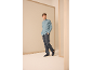 Homme en chemise bleu clair et pantalon bleu foncé.