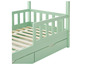 Un lit d'enfant vert clair avec une barrière et deux tiroirs.