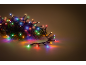 Guirlande lumineuse LED colorée entrelacée avec des branches de sapin vertes, projetant des reflets vifs.