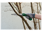 Une main gantée utilise une scie à main Parkside pour tailler un arbre.