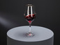 Un verre de vin rouge sur un fond gris.