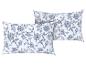 Deux oreillers décoratifs à motif floral bleu sur fond blanc.