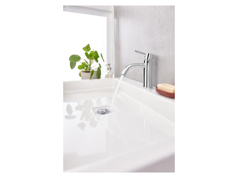 Un lavabo avec un robinet chromé qui coule.
