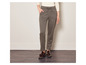 Une femme porte un pantalon à carreaux et des mocassins marron foncé.