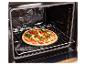 Pizza aux légumes sur une plaque de cuisson dans un four ouvert.
