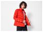 Une femme porte une veste matelassée rouge.