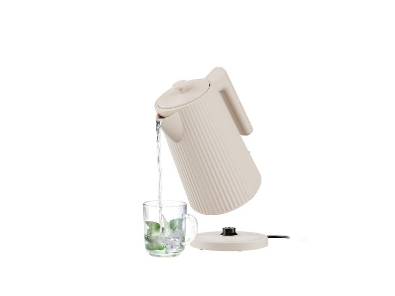 Une bouilloire blanche avec une tasse de menthe