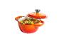 Cocotte en fonte orange avec couvercle, remplie d'un ragoût de viande, haricots et légumes.