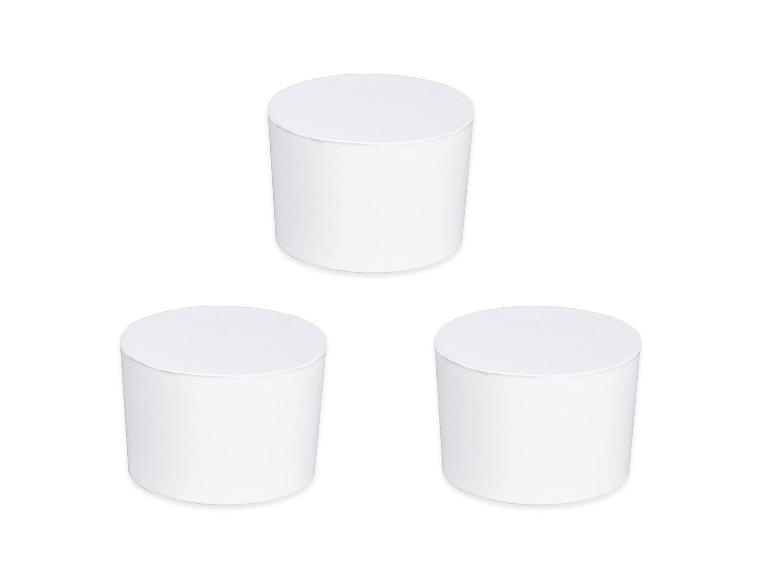 Trois récipients cylindriques blancs sur fond blanc.