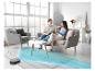 Robot aspirateur nettoyant un tapis pendant qu'un couple se détend sur le canapé.