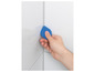 Une main utilise une spatule bleue pour lisser une surface.