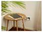 Tablette en charge sur une table en bois près d'une plante, branchée à une prise murale.