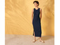 Une femme porte une robe bleu foncé et des sandales beiges.