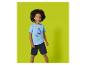 Garçon en t-shirt bleu clair avec motif de bateau et short bleu marine.