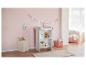 Une commode blanche avec un matelas à langer, un panier et des jouets dans une chambre de bébé.