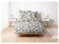 Un lit avec une couette blanche à motif floral noir.