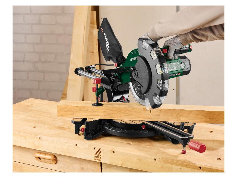 Une personne coupe du bois avec une scie à onglet sur un établi.