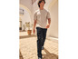 Homme en T-shirt gris et pantalon cargo noir marchant dans une ruelle.