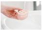 Un réservoir d'eau rose est rempli d'eau dans un lavabo.