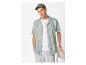 Homme en chemise rayée, t-shirt blanc, short gris et casquette.