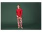 Un homme porte un pyjama rouge à thème de Noël avec un motif d'homme en pain d'épices