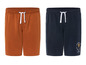 Deux shorts, un bleu foncé avec l'impression 'Summer Travel Beach Club', un marron.