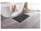 Tapis de bain gris foncé près d'une baignoire blanche.