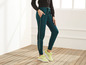 Femme portant un pantalon de survêtement Jette Joop vert avec des baskets jaunes.