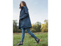Une femme portant un imperméable bleu et des bottes de pluie bleues avec des accents rouges.