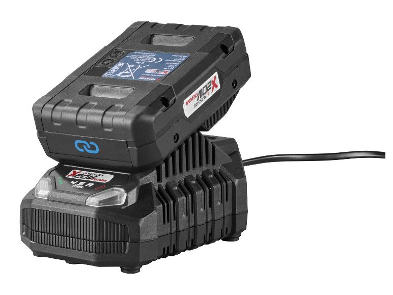 Une batterie d'outil électrique noire en charge sur un chargeur noir avec un cordon d'alimentation.