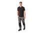 Homme en polo noir et pantalon de travail gris.