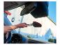 Une personne nettoie l'intérieur d'une voiture avec une brosse.