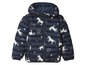 Une veste matelassée bleu marine à capuche, avec un motif arc-en-ciel, étoiles et licornes.