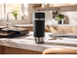 Mug isotherme noir sur un comptoir de cuisine avec un ordinateur portable et des clés.