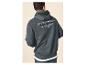 Homme en sweat à capuche gris foncé avec le texte 'THE DENIM CLUB Crafted Garments ORIGINAL DENIMS' au dos.