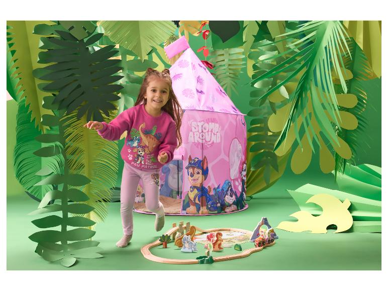 Fille en leggings roses LUPILU® jouant dans une chambre d'enfant sur le thème de la jungle.