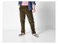 Homme en pantalon de velours côtelé marron, t-shirt rose et chemise en jean.