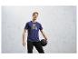 Homme portant un t-shirt violet avec un ballon de fitness.