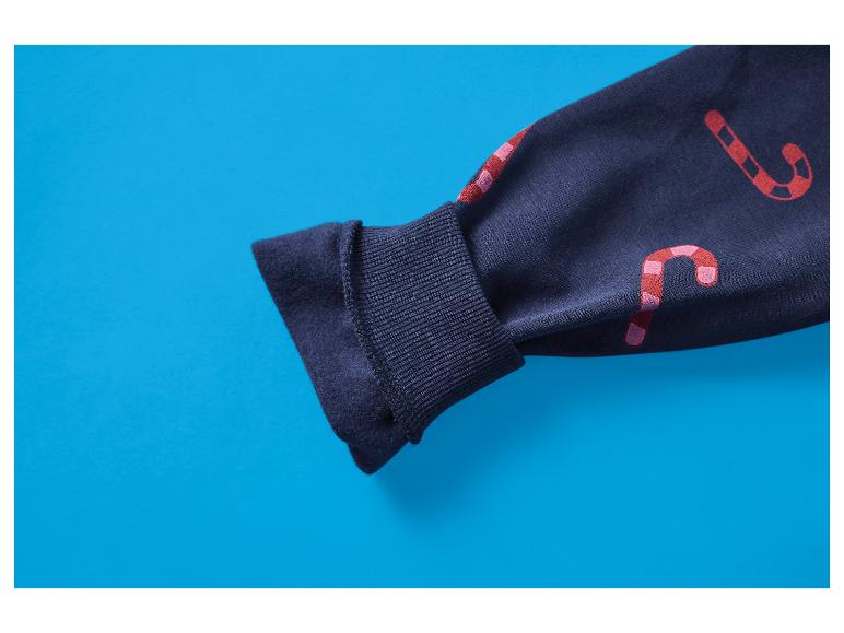 Manche de sweat-shirt bleu foncé avec des motifs de cannes à sucre rouges et roses sur fond bleu