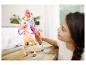 Poupée Barbie sur un cheval et une petite fille qui joue.