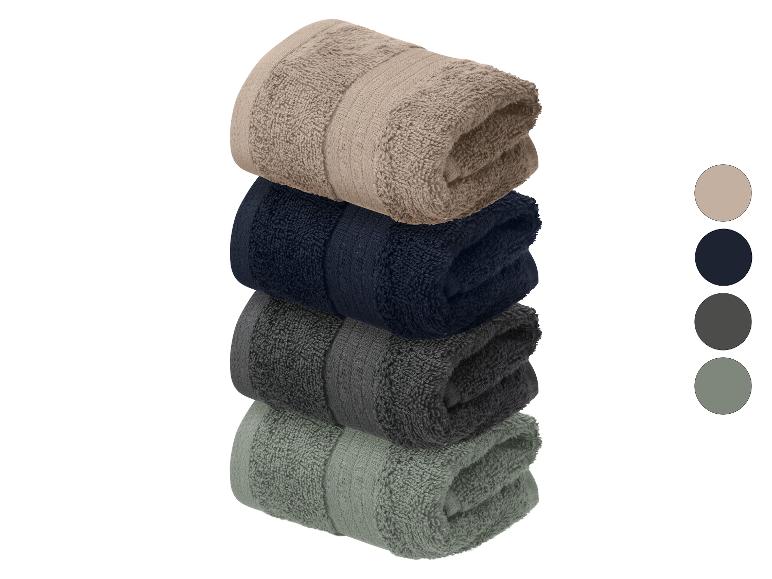 Ensemble de quatre serviettes pliées aux couleurs neutres : beige, bleu marine, gris foncé et vert-gris.