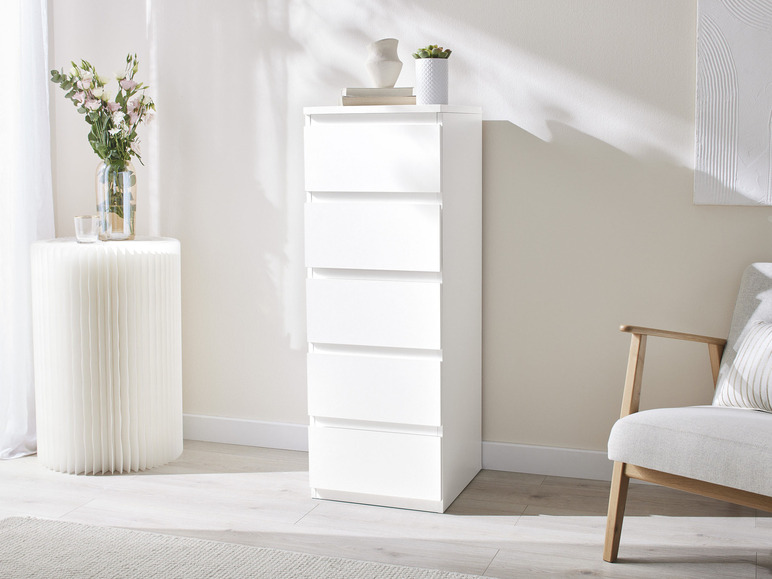 Une commode blanche avec cinq tiroirs dans un salon moderne.